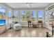 Bright sunroom with large windows offering panoramic views and comfortable seating arrangement at 4702 Blockhouse Ln, Hollywood, SC 29449