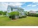 A view of the home's backyard features a screened porch and well-maintained lawn at 489 Dolphin Dr, Summerville, SC 29485