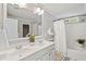 Bright bathroom with double vanity, large mirror, and shower-tub combination with curtain at 489 Dolphin Dr, Summerville, SC 29485