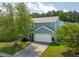 Two-story home with a two-car garage, lush green lawn, mature tree and front garden at 489 Dolphin Dr, Summerville, SC 29485