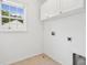 Bright laundry room featuring white cabinets, a window, and tile floor at 489 Dolphin Dr, Summerville, SC 29485