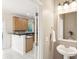Bright powder room with pedestal sink, decorative mirror, and views into kitchen area at 489 Dolphin Dr, Summerville, SC 29485