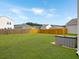 Expansive backyard with a lush green lawn, bordered by a wooden privacy fence and mature trees at 5003 Ferry Field Dr, Summerville, SC 29485