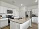 Modern kitchen features an island with granite countertops, stainless steel appliances, and white cabinetry at 5003 Ferry Field Dr, Summerville, SC 29485