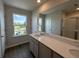 Well-lit bathroom featuring a wide window view, wood-look flooring, and a vanity with quartz countertop at 5100 Double Eagle, Summerville, SC 29485