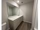 Cozy bathroom with wood-look flooring, a single vanity with a quartz countertop, and a large mirror at 5100 Double Eagle, Summerville, SC 29485