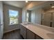 Well-lit bathroom featuring a wide window view, wood-look flooring, and a vanity with quartz countertop at 5100 Double Eagle, Summerville, SC 29485