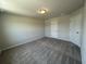 A well-lit bedroom features neutral walls, two white doors, carpeted floor, and a simple ceiling light at 5100 Double Eagle, Summerville, SC 29485
