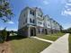 Row of new townhomes with brick and white siding, manicured lawns and paved walkways at 5100 Double Eagle, Summerville, SC 29485