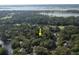 An aerial view shows the property's location amidst lush trees, a golf course, and a serene body of water at 5504 Green Dolphin Way, Kiawah Island, SC 29455