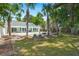 A backyard oasis with a pool, patio, firepit, palm trees, and a covered porch area offers a perfect space for outdoor relaxation at 569 Pointe Of Oaks Rd, Summerville, SC 29485