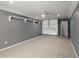 A carpeted bedroom with a ceiling fan, window, and a shelf along the upper portion of the wall and a built-in shelf in the corner at 569 Pointe Of Oaks Rd, Summerville, SC 29485