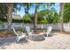 A cozy patio area features a brick fire pit, white Adirondack chairs, and a white fence to create a peaceful outdoor retreat at 569 Pointe Of Oaks Rd, Summerville, SC 29485