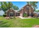 All brick home with tidy lawn and mature landscaping, including palm trees and green shutters at 569 Pointe Of Oaks Rd, Summerville, SC 29485
