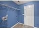 Bright laundry room featuring wood-look flooring, blue walls, washer and dryer hookups, and wire shelving at 569 Pointe Of Oaks Rd, Summerville, SC 29485