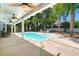 Lush backyard with a well-manicured patio with a pristine pool, lounge furniture, and mature palm trees at 569 Pointe Of Oaks Rd, Summerville, SC 29485