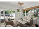 A sun room with comfortable wicker furniture and glass doors overlooking the pool and yard at 569 Pointe Of Oaks Rd, Summerville, SC 29485
