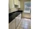 Galley kitchen with sleek, black countertops, white cabinets and stainless steel sink at 6 Town Park Ln # C, Charleston, SC 29412