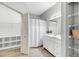 A full bathroom with wood-look floors, white vanity, large mirror, and walk-in closet for storage at 60 Fenwick Hall Aly # 415, Johns Island, SC 29455