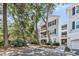 Charming gray multi-story condo building with balconies and lush landscaping in a desirable neighborhood at 60 Fenwick Hall Aly # 415, Johns Island, SC 29455