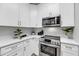 Close-up of kitchen with stainless steel appliances, white cabinets, and quartz countertops at 60 Fenwick Hall Aly # 415, Johns Island, SC 29455
