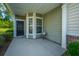 Inviting front porch with a black door, sidelight windows, and neutral colored siding at 626 Battery Edge Dr, Summerville, SC 29486