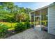 A view of the patio outside the screened-in porch showing lush backyard with trees and bushes at 626 Battery Edge Dr, Summerville, SC 29486
