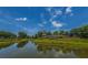 Reflective pond with the community entrance tower, blue sky, and landscaping at 626 Battery Edge Dr, Summerville, SC 29486