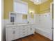 Bright bathroom with double vanity, hardwood floors, and a shower-tub combination at 634 Rutledge Ave, Charleston, SC 29403
