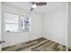 Bedroom with two windows, wood-look floors, white walls and trim, and a ceiling fan at 634 Rutledge Ave, Charleston, SC 29403