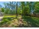 A large backyard with green grass and mature trees lining the perimeter at 689 W Butternut Rd, Summerville, SC 29483