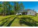 Spacious backyard featuring a home, shed, and mature trees providing shade at 689 W Butternut Rd, Summerville, SC 29483