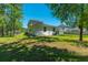 View of home's backyard featuring mature trees and lush green grass at 689 W Butternut Rd, Summerville, SC 29483