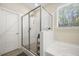 Modern bathroom with a glass enclosed shower, separate bathtub, and large window at 689 W Butternut Rd, Summerville, SC 29483