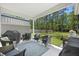 Covered patio with comfortable seating, outdoor grill, and view of the spacious, tree-lined backyard at 689 W Butternut Rd, Summerville, SC 29483