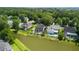 Aerial view of a neighborhood showcasing homes with backyard pools and lake views surrounded by lush green trees at 6910 Tanner Hall Blvd, Hanahan, SC 29410