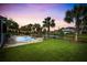 Inviting backyard pool area with palm trees, string lights, and lush green lawn at 6910 Tanner Hall Blvd, Hanahan, SC 29410