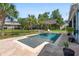 Serene backyard showcasing a sparkling pool with a tanning ledge, lush landscaping, and privacy fencing at 6910 Tanner Hall Blvd, Hanahan, SC 29410