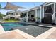 Luxurious backyard featuring a spacious pool with a tanning ledge, lush landscaping, and a covered patio at 6910 Tanner Hall Blvd, Hanahan, SC 29410