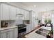 White kitchen featuring granite countertops, stainless steel appliances, and an eat-in dining area at 6910 Tanner Hall Blvd, Hanahan, SC 29410