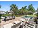 Inviting pool area with travertine tile, dining table, lounge chairs, palm trees, and an in-ground pool at 6910 Tanner Hall Blvd, Hanahan, SC 29410