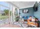 Cozy screened porch with stylish furniture, a large TV, and views of the backyard pool and lush greenery at 6910 Tanner Hall Blvd, Hanahan, SC 29410