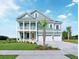 Spacious two-story home with a welcoming front porch, a three-car garage and manicured lawn at 708 Breakers Reef Ln, Huger, SC 29450