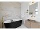 Modern bathroom features a freestanding tub, unique fixtures, and vanity with ample counter space and storage at 71 Moultrie St, Charleston, SC 29403