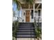 Charming front porch with a wooden door, and black railings, showcasing the home's curb appeal at 71 Moultrie St, Charleston, SC 29403