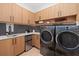 Modern laundry room with custom wood cabinetry, countertop space, sink, and stainless steel appliances at 71 Moultrie St, Charleston, SC 29403