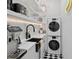 Beautiful laundry room features custom shelves, washer and dryer, sink and checkered floors at 71 Moultrie St, Charleston, SC 29403