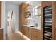Chic wet bar with custom oak cabinets, a white countertop, and a wine refrigerator for ultimate convenience and entertainment at 71 Moultrie St, Charleston, SC 29403