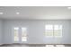 Bright living room featuring wood floors, white walls, a large window, and French doors to the exterior at 740 Meadowbrook Lane, Summerville, SC 29486
