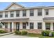 Charming townhome with white siding, stone accents, and a covered entryway, creating curb appeal at 7812 Park Gate Dr, North Charleston, SC 29418